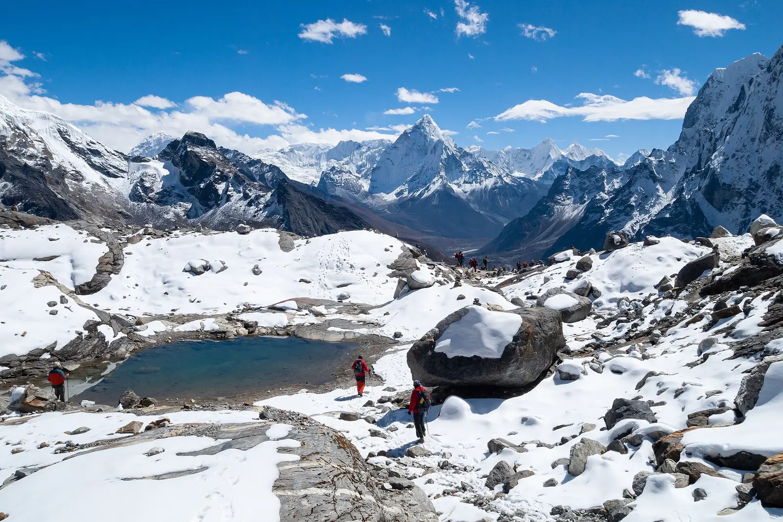 Trekkers by a frozen lake in the Cho La valley