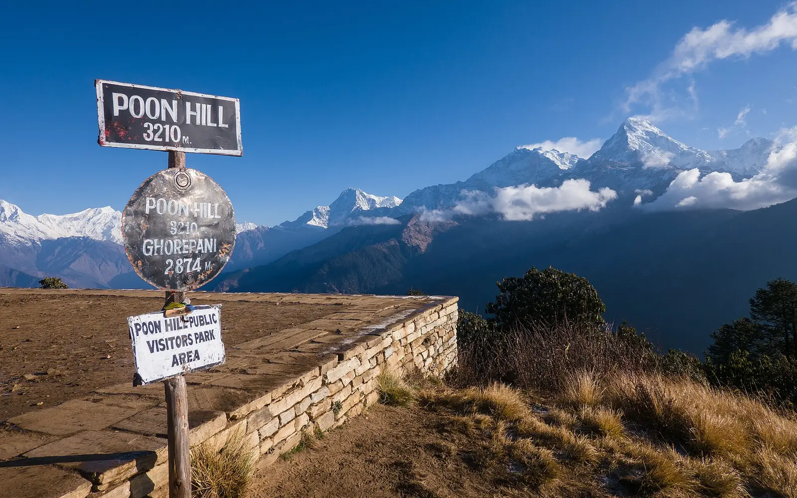 The Poon Hill sign at 3,210 m with the Annapurna range behind